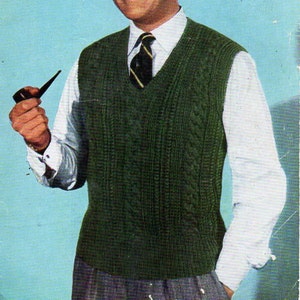 Op de afbeelding: Vintage breipatroonadvertentie met een man in een groene kabelgebreide vest, een wit overhemd en een stropdas. Het patroon is voor borstmaten van 96.5 tot 106.7 cm. Het Bestway Knitwear-logo is zichtbaar.
