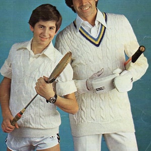 Puede incluir: Dos personas vistiendo suéteres de punto blanco y pantalones blancos. La persona de la izquierda sostiene una raqueta de tenis. La persona de la derecha sostiene una raqueta de tenis y un guante. El fondo es una pared azul claro. El texto "Wendy D.K." y "1822" está en la parte superior de la imagen. El texto "86-112cm. (34-44ins.)" está en la parte inferior de la imagen.