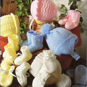 Op de afbeelding: Een set gebreide babyschoentjes, mutsen en wanten in roze, blauw en wit. De schoentjes hebben een simpel ontwerp en zijn gemaakt van zacht garen. De mutsen zijn ook simpel en hebben een pompon bovenop. De wanten zijn klein en hebben een simpel ontwerp.