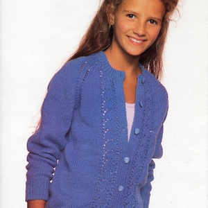 May include: A blue knitted cardigan with a lace pattern and button fastening. The cardigan has a round neckline and long sleeves.