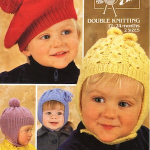 May include: A knitting pattern booklet for making baby hats. The booklet features four different hat designs: a red beret, a yellow hat with a lacy pattern, a purple hat with a pom-pom, and a blue hat with ear flaps. The booklet is titled "Emu Double Knitting 12-24 months 2 sizes".