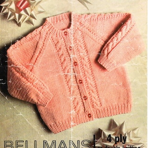 May include: A pink knitted cardigan with a cable knit pattern and button closure. The cardigan is for sizes 18 to 26 and is made with 4 ply yarn or double knitting yarn. The pattern is from Bellmans.