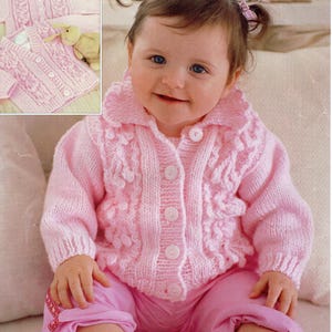 May include: A pink knitted baby cardigan with a button closure and a ruffled collar. The cardigan is made with a textured stitch pattern and has a  'Supersoft Baby Aran' label. The pattern number is 3189 and the size is 41-66cm (16-26in).