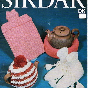 May include: A knitting pattern booklet with the title "Sirdar" and the number "5611" printed on the cover. The booklet features images of knitted items, including a pink teapot cozy, a white teapot cozy with a red pom-pom, and a pair of white knitted mittens.