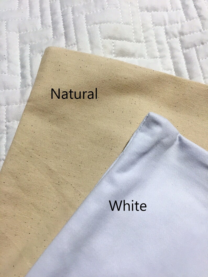 K&ouml;nnte beinhalten: Zwei Stoffmuster, eines in Naturbeige und eines in Wei&szlig;, mit den Worten "Natur" und "Wei&szlig;" bedruckt.