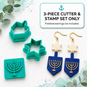 May include: A 3-piece teal plastic cutter and stamp set for clay, including a dreidel shape, a Star of David shape, and a square menorah stamp. Beside the cutters are two finished earrings featuring a cream Star of David and a blue menorah.