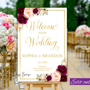 Könnte beinhalten: Ein weißes Hochzeitsschild mit goldenen Buchstaben und burgunderroten und blushfarbenen floralen Akzenten. Das Schild lautet "Willkommen zu unserer Hochzeit Sophia & Brandon 10.5.2019 Vielen Dank, dass Sie mit uns diesen besonderen Tag feiern!"
