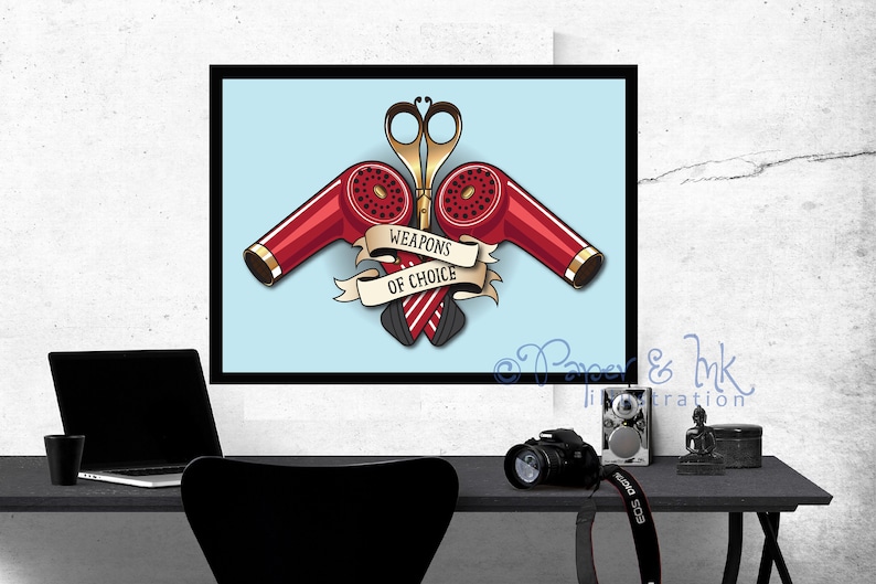 May include: A vintage-style illustration of two red hair dryers and a pair of scissors crossed over each other. The illustration is on a light blue background with a banner that reads "Weapons of Choice".