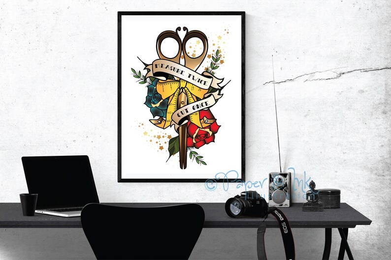 May include: A white background with a gold and red tattoo-style illustration of a pair of scissors, a measuring tape, and a rose. The text "Measure Twice Cut Once" is written on a banner.