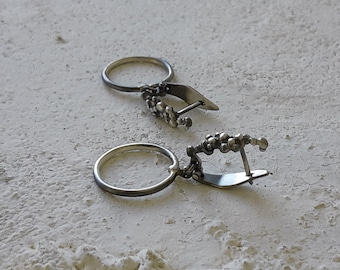 Silver hoops dangle on a grained latch back earrings, handcrafted in sterling silver.