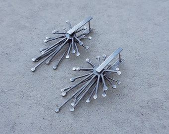 Stora kinetiska örhängen tillverkade av oxiderat sterlingsilver, med spärr baktill.