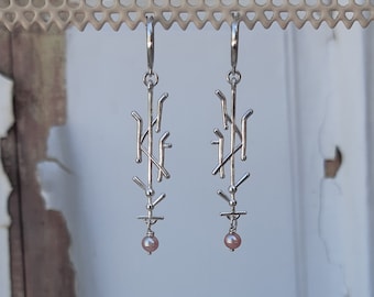 A pair of long dangle earrings from the "Dance notation" series.