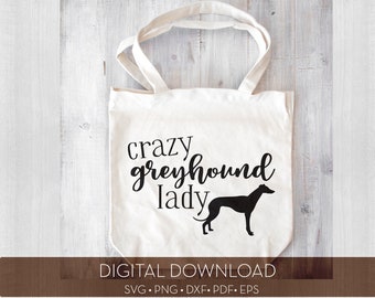 May include: A white tote bag with black text that reads "crazy greyhound lady" and a black silhouette of a greyhound dog. The bag is on a light wood background.