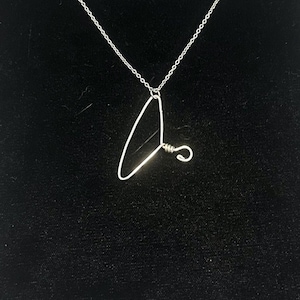 May include: A silver necklace with a pendant shaped like a hanger. The pendant is made of wire and has a small loop at the top.