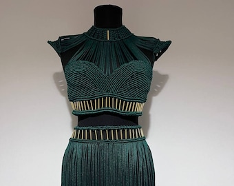 May include: A green crochet top and skirt set with gold accents. The top has a halter neckline and the skirt has a fringe hem.