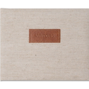 May include: A rectangular guest book with a beige linen cover. A brown leather patch with the word "VISITORS" is centered on the cover. The book is closed and sits on a white background.