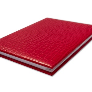 May include: A red leather-bound notebook with a crocodile-embossed pattern.