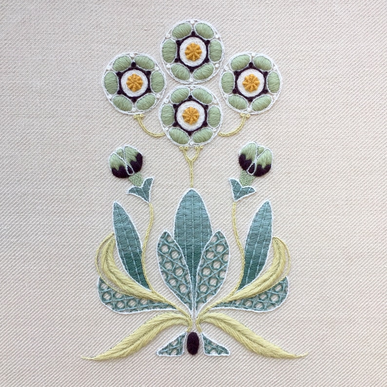 May include: Embroidered floral design with green and yellow flowers and leaves on a white fabric background.