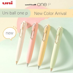 May include: Four Uni-ball One P pens in pastel shades: cream, pink, yellow, and pale green. Each pen features a silver clip and a conical tip. The image includes the text "Uni ball one p" and "New Color Arrival".