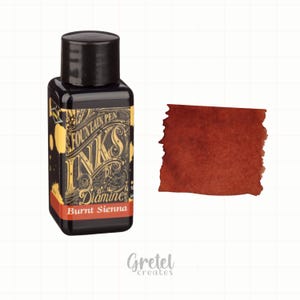 Puede incluir: Una botella de tinta negra con la etiqueta "Fountain Pen Inks by Diamine" y el texto "Burnt Sienna". Una muestra de la tinta muestra un color marrón rojizo intenso. La botella tiene una tapa negra y una etiqueta decorativa.