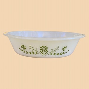May include: White oval baking dish with a green floral design. The design features small green leaves and flowers.