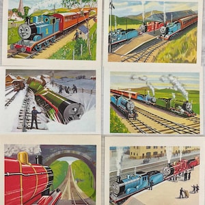 Peut inclure: Ensemble de six illustrations vintage de Thomas le petit train. Les images montrent les locomotives bleues, rouges et vertes dans diverses scènes ferroviaires, dont un déraillement et des trains en gare. Les illustrations ont un style classique, de type livre d'histoires.
