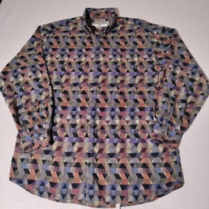 May include: Button-down shirt with a geometric pattern in shades of blue, purple, pink, and gray. The long-sleeved shirt has a collared neckline and buttoned cuffs. The shirt is made of a woven fabric.