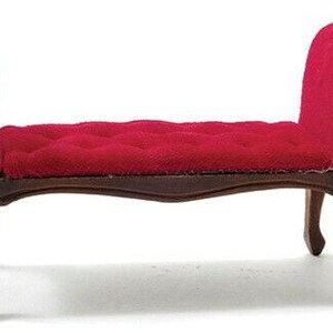 May include: Miniature red velvet bench with a tufted seat and curved wooden legs. The bench has scrolled armrests and a dark wood frame, evoking a classic, antique style. The bench is a decorative item.