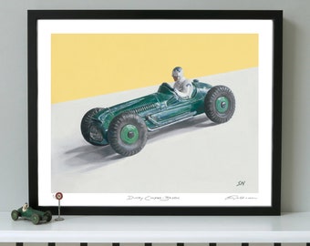 Puede incluir: Una impresión enmarcada de un coche de juguete verde con un conductor. El coche está sobre un fondo amarillo. La impresión está titulada "Dinky Cooper Bristol" y firmada "SN".