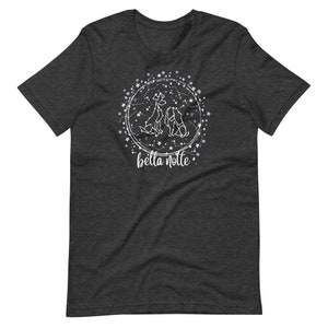 Puede incluir: Una camiseta gris oscuro jaspeada con un dise&ntilde;o blanco de tres perros en un c&iacute;rculo de constelaci&oacute;n. El texto "bella notte" est&aacute; debajo del c&iacute;rculo.