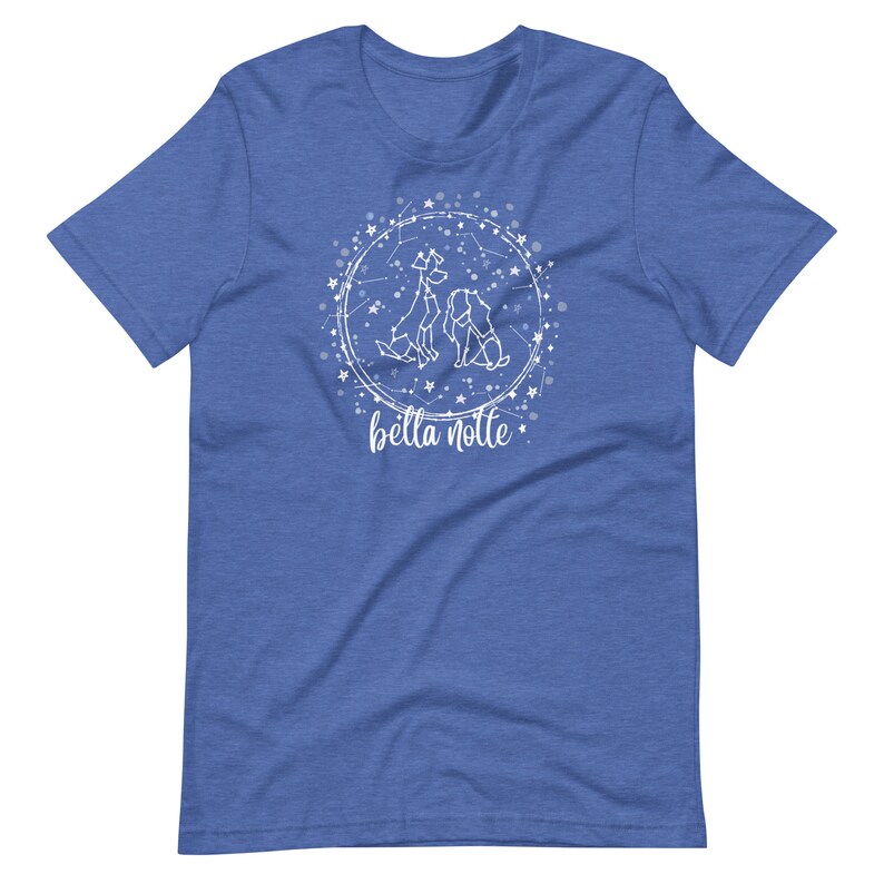 Puede incluir: Una camiseta azul real con un dise&ntilde;o blanco de tres perros formando una constelaci&oacute;n con estrellas y el texto "bella notte".