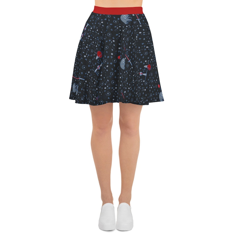 May include: A black skater skirt with a red waistband. The skirt features a repeating pattern of stars, spaceships, and lightsabers.