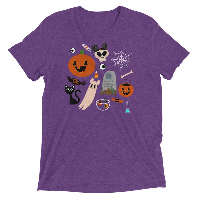 K&ouml;nnte beinhalten: Lilafarbenes T-Shirt mit einem Halloween-Design. Das Design umfasst einen K&uuml;rbis, einen Totenkopf, einen Geist, ein Spinnennetz, S&uuml;&szlig;igkeiten und eine schwarze Katze. Das T-Shirt besteht aus einem weichen, bequemen Material.