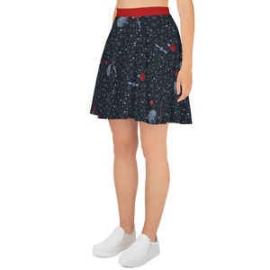 May include: A black skater skirt with a space-themed print featuring stars, planets, and spaceships. The skirt has a red waistband.