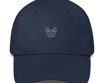 Könnte beinhalten: Eine marineblaue Baseballkappe mit einem weißen gestickten Design eines Globus innerhalb von Mickey Mouse Ohren.