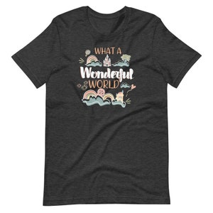 May include: Dark heather grey t-shirt with a whimsical design featuring a castle, rainbows, and the text "What a Wonderful World".