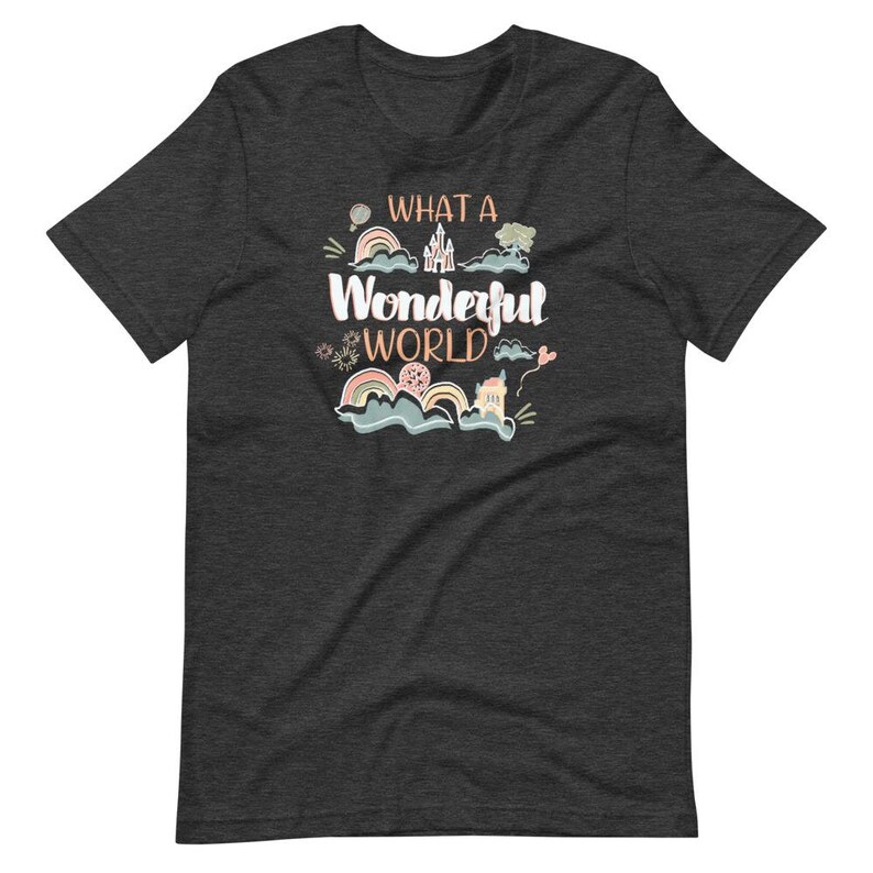 May include: Dark heather grey t-shirt with a whimsical design featuring a castle, rainbows, and the text "What a Wonderful World".