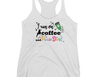 May include: White tank top with a black graphic that says "I run on coffee and pixie dust". The graphic also includes a green coffee cup and a silhouette of Tinkerbell.