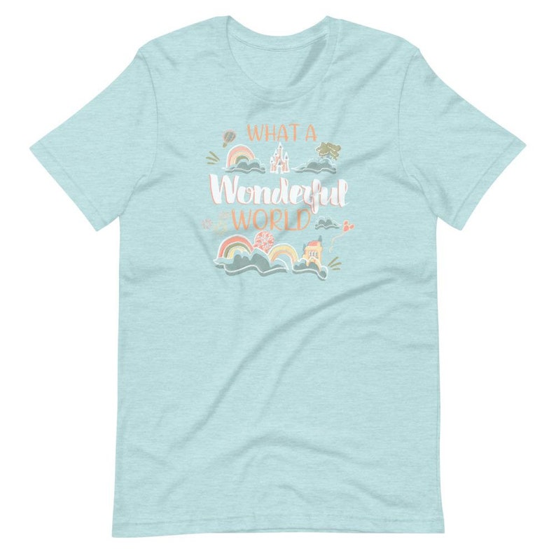 May include: A light blue t-shirt with a whimsical design featuring a castle, rainbows, and the text "What a Wonderful World".