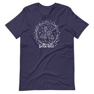 Puede incluir: Una camiseta azul marino con un dise&ntilde;o blanco de tres perros en un c&iacute;rculo de constelaci&oacute;n. El texto "bella notte" est&aacute; debajo del c&iacute;rculo.