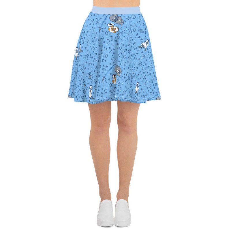 Puede incluir: Una falda skater azul claro con un patr&oacute;n blanco y azul de personajes y s&iacute;mbolos de Star Wars.
