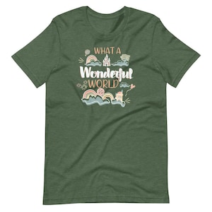 May include: A green t-shirt with the text "What a Wonderful World" in a whimsical font. The design features a castle, clouds, rainbows, and other whimsical elements.