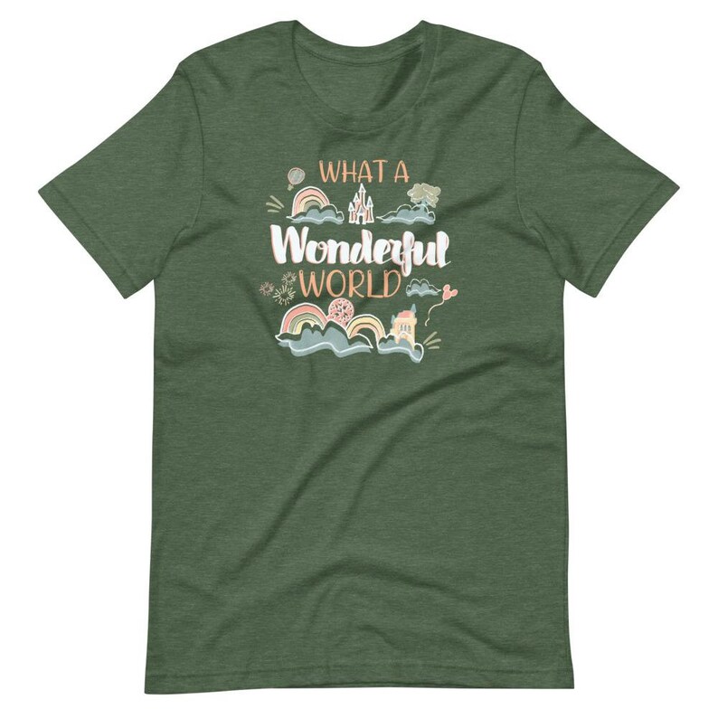 May include: A green t-shirt with the text "What a Wonderful World" in a whimsical font. The design features a castle, clouds, rainbows, and other whimsical elements.