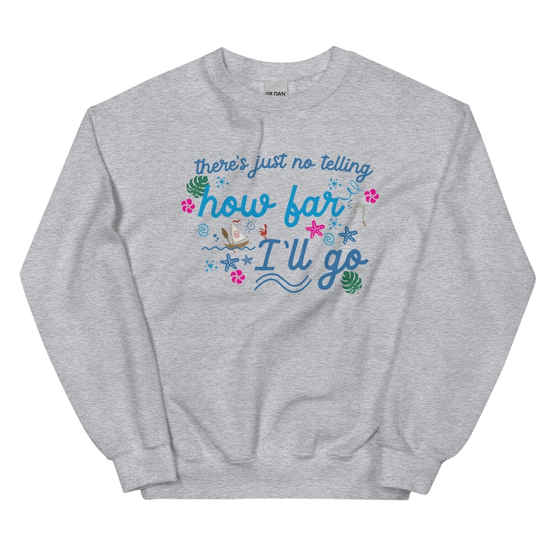 May include: A light gray sweatshirt with the text "there's just no telling how far I'll go" in blue and turquoise script. The design includes tropical flowers, a boat, and starfish.