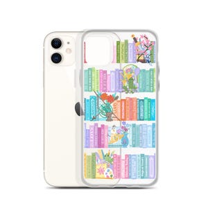 May include: Clear phone case with a colorful bookshelf design. The case features rows of illustrated books with titles like "Love", "Swords", and "Bears". The design includes whimsical elements such as flowers, frogs, and a bird, creating a playful aesthetic.