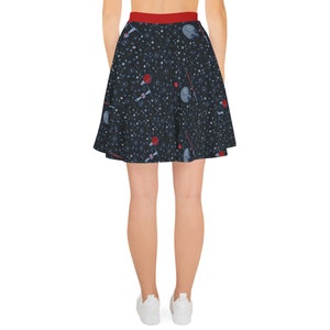 May include: A black skater skirt with a red waistband and a space-themed print featuring stars, planets, and spaceships.