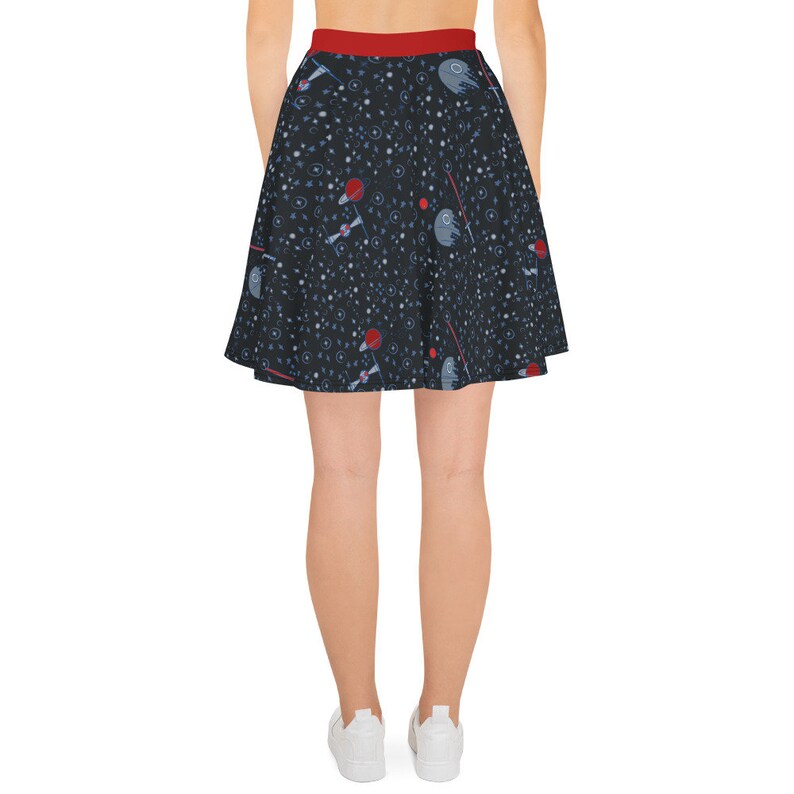 May include: A black skater skirt with a red waistband and a space-themed print featuring stars, planets, and spaceships.