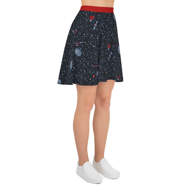 May include: A black skater skirt with a red waistband and a space-themed print featuring stars, planets, and spaceships.