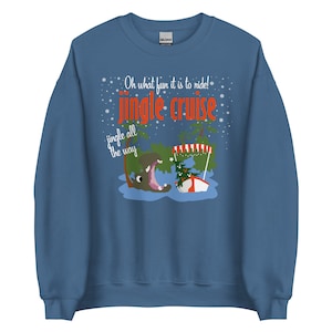 May include: A blue sweatshirt with the text "Oh what fun it is to ride! Jingle Cruise jingle all the way." The graphic features a hippo, a Christmas tree, and a boat. The sweatshirt is a crew neck style.