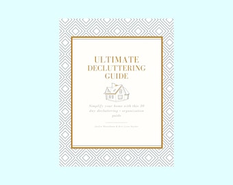 May include: A white and gold cover with a geometric pattern. The cover has the text "ULTIMATE DECLUTTERING GUIDE" and a simple line drawing of a house. The text below the house reads "Simplify your home with this 30 day decluttering & organization guide.  Jackie Manchester & Kari Lynn Snyder"
